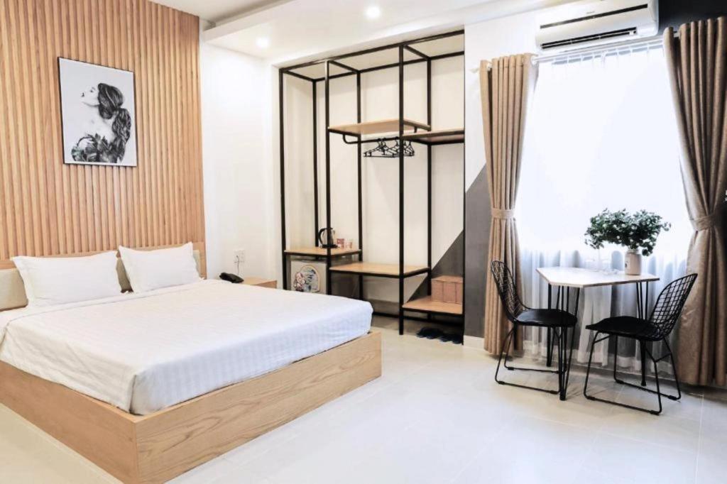 a bedroom with a bed and a table and chairs at Hoang Anh Hotel Vung Tau in Vung Tau