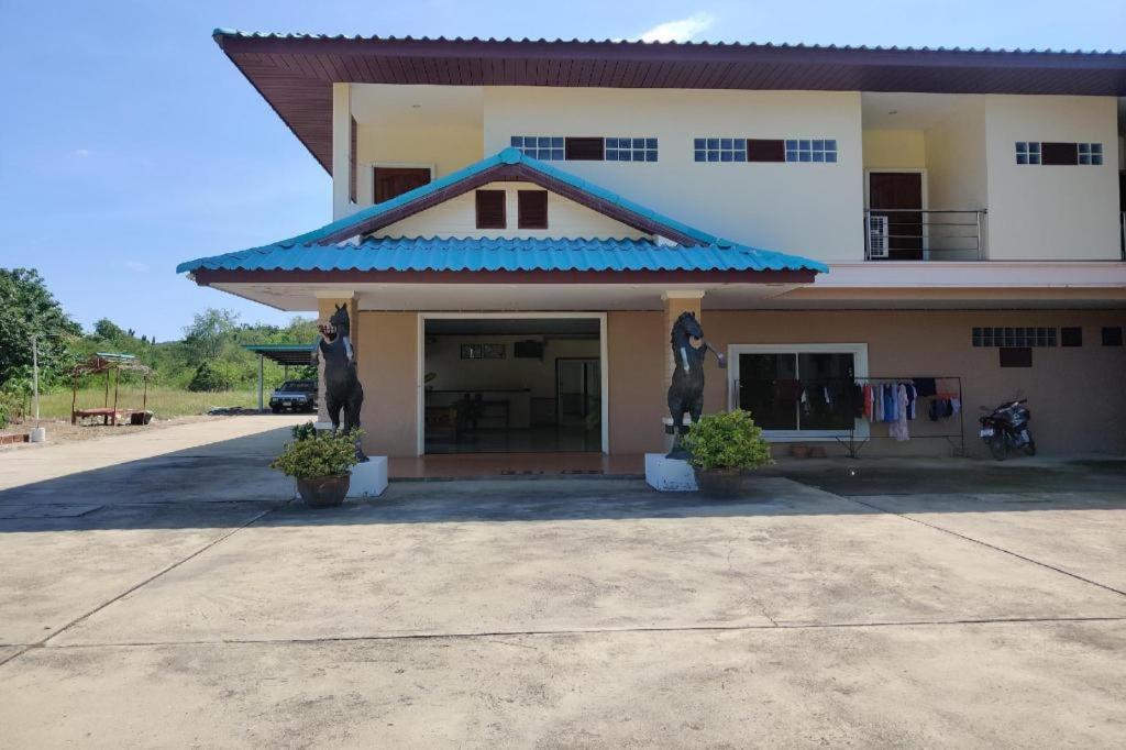 a building with two statues in front of it at OYO 75334 Train Hotel in Ban Don Rak
