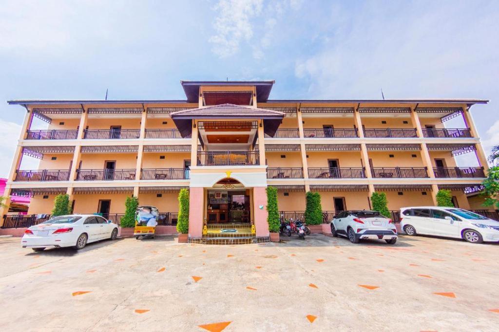 a large building with cars parked in a parking lot at OYO 561 Kor Wanburi in Prachuap Khiri Khan