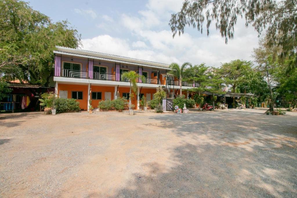 a building with a large yard in front of it at OYO 931 Sor Chareanpanit in Ban Khlot