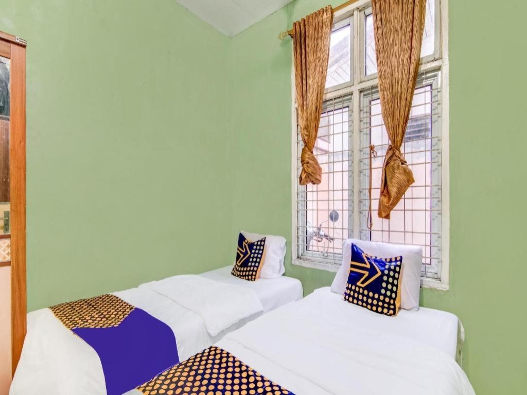 Ένα ή περισσότερα κρεβάτια σε δωμάτιο στο Hotel O Nayla Homestay Syariah Near Koro Koro Panam, Karaoke, Pool, & Cafe