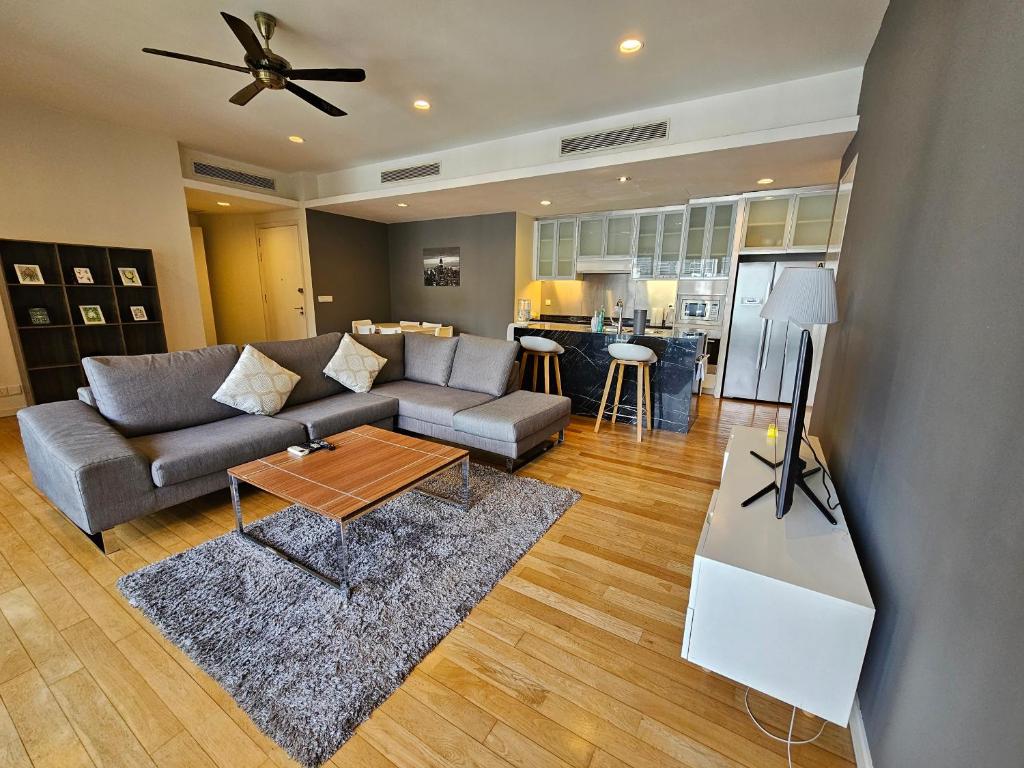 una sala de estar con un sofá y una mesa en Resort Style Haven 3BR6pax St Mary KLCC Twin Towers View, en Kuala Lumpur