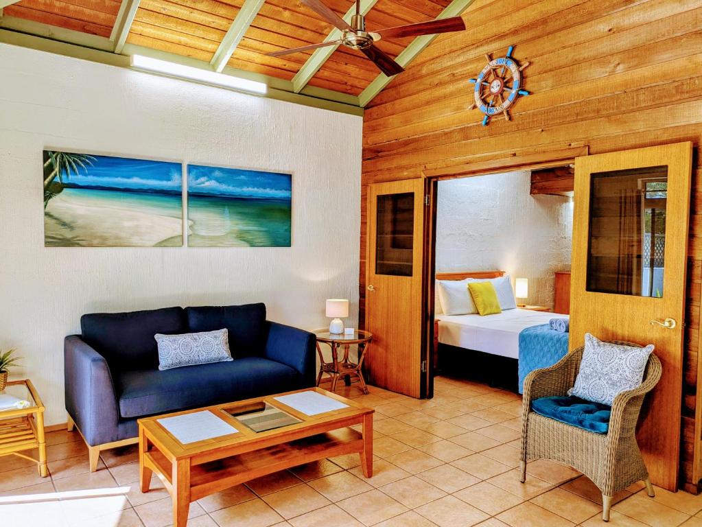 a living room with a couch and a bed at Beachside Cottage - A Private Peaceful Hidden Gem 50m to Beach in Nelly Bay