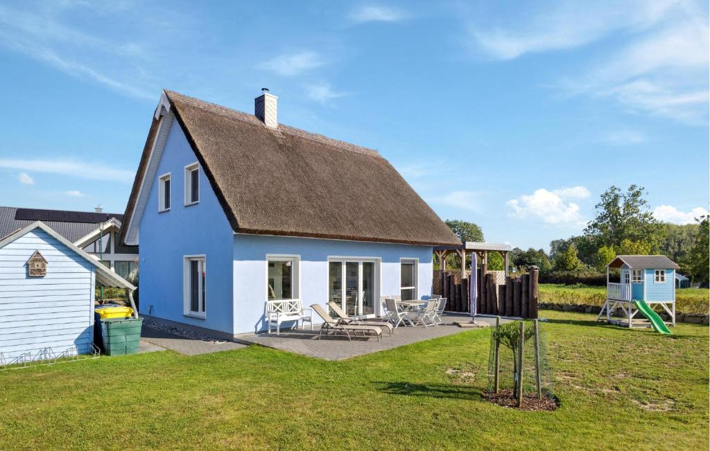 a blue and white house with a yard at Nice Home In Glowe With Wifi in Glowe