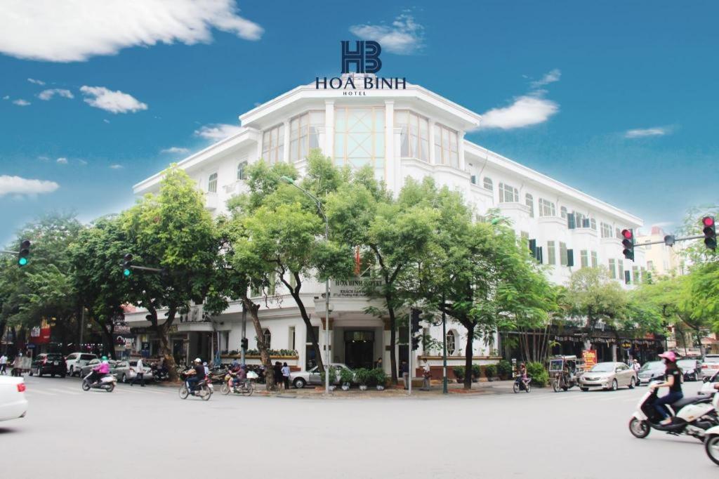 a rendering of a building with people riding motorcycles at Hoa Binh Hotel in Hanoi