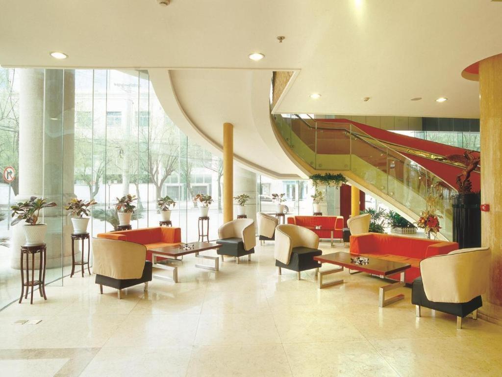 eine Lobby mit Stühlen und Tischen und einer Treppe in der Unterkunft Xian Union Alliance Atravis Executive Hotel in Xi'an