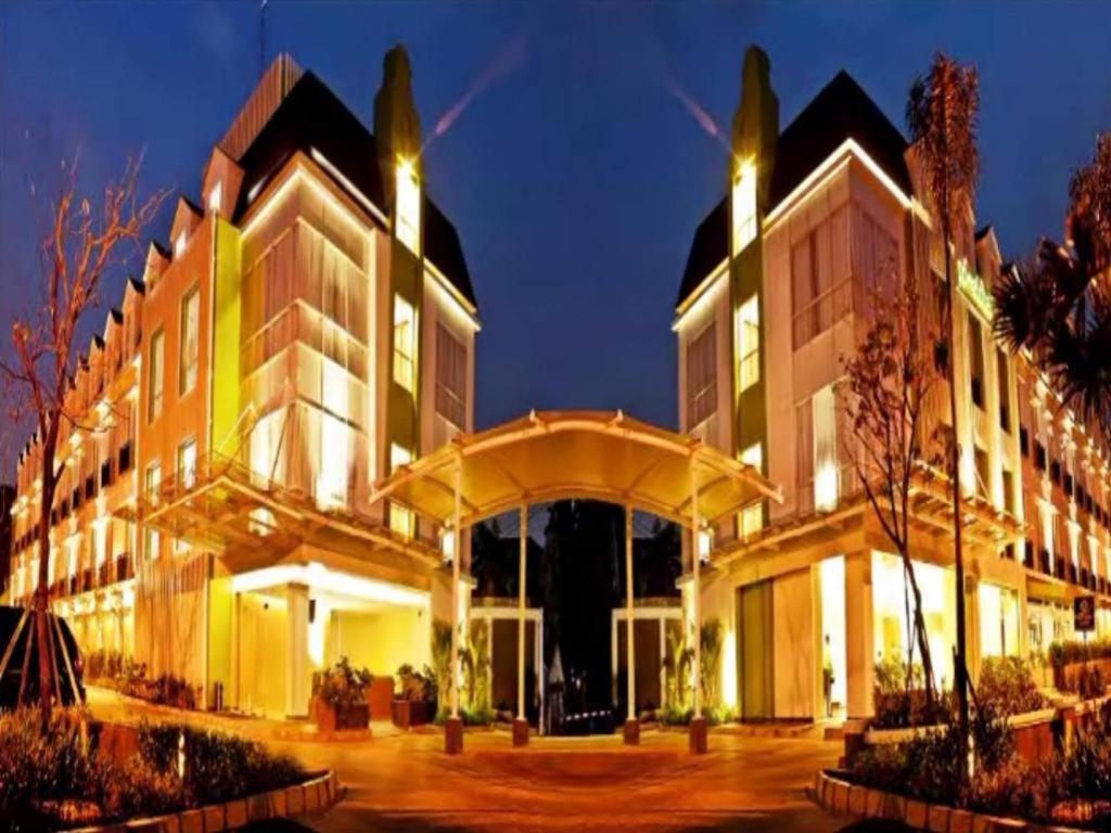 un gran edificio con muchas ventanas por la noche en Pomelotel Patra Kuningan Jakarta, en Yakarta