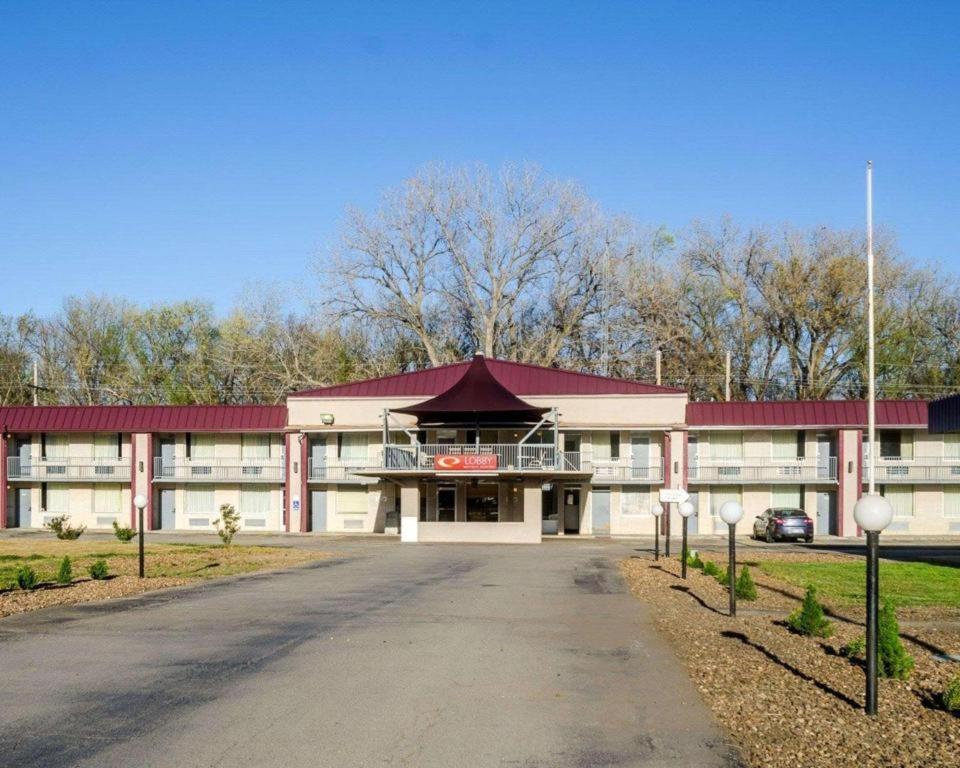 a large white building with a red roof at SureStay Hotel in Salina