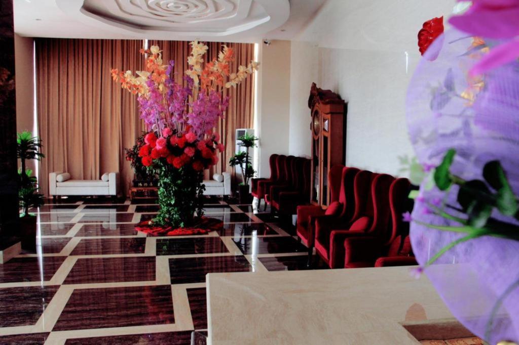 ein Raum mit Stühlen und einer großen Blumenvase in der Unterkunft The Belagri Hotel and Convention in Sorong