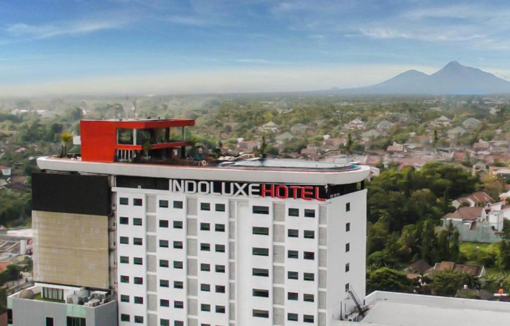 a building with a novo use hotel on top of it at Indoluxe Hotel Jogjakarta in Kejayan