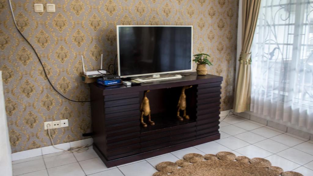 ein Wohnzimmer mit einem TV auf einem Schrank in der Unterkunft Villa Pesona Merapi With 3 BR in Ngaglik