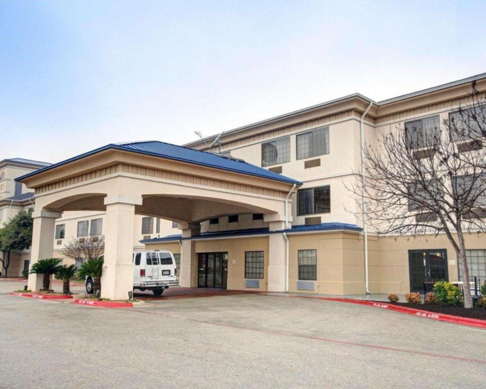 a building with a van parked in front of it at Quality Inn & Suites Airport in Austin