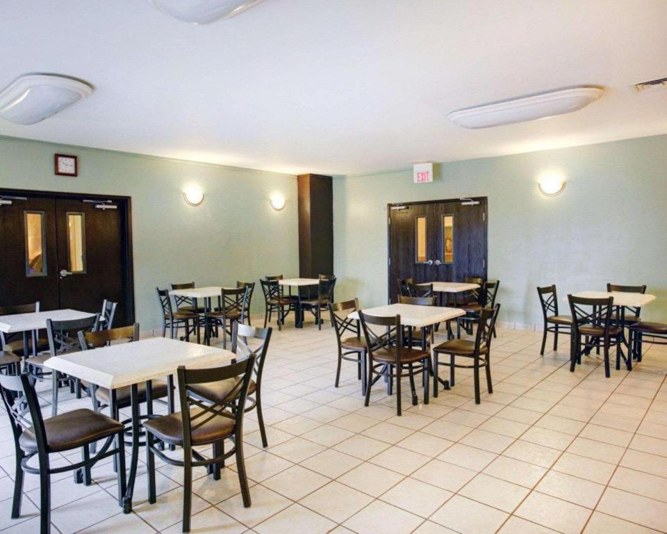 a dining room filled with tables and chairs at Quality Inn & Suites Airport in Austin