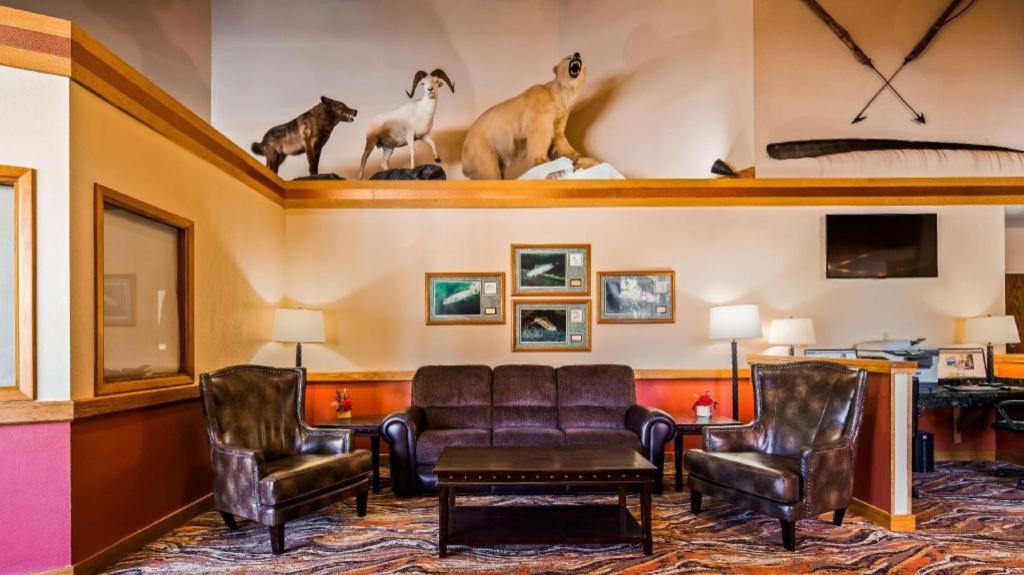 a living room with couches chairs and a tv at Best Western Lake Lucille Inn in Wasilla