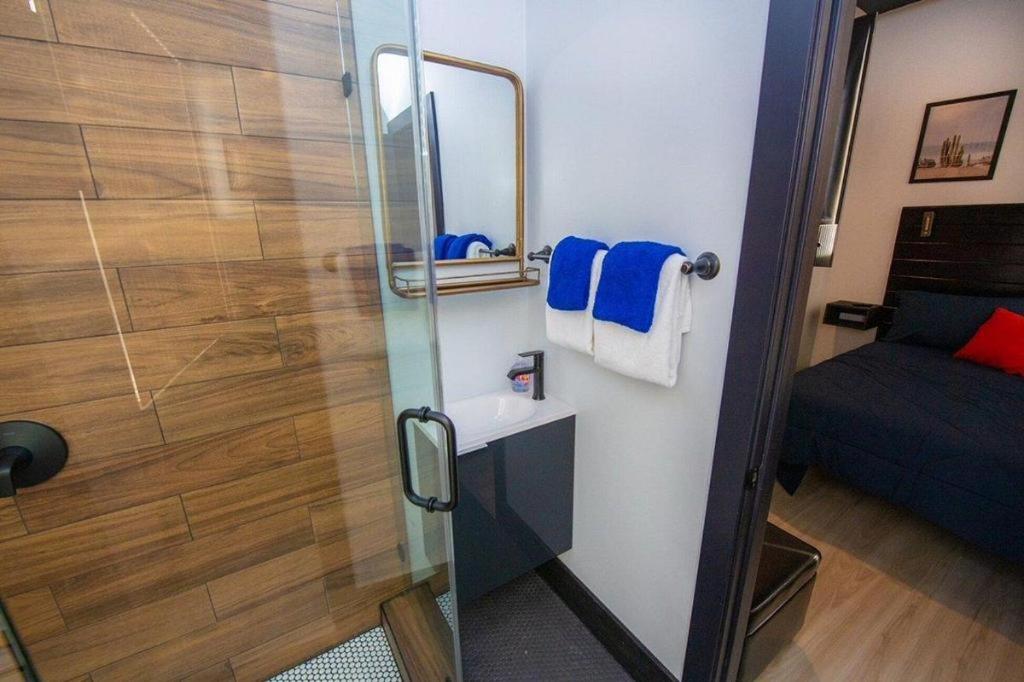 a bathroom with a shower with a sink and a mirror at Balboa Park Hotel Downtown Little Italy in San Diego