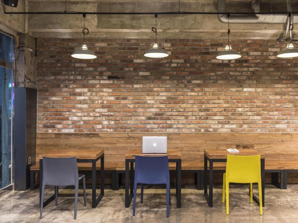 a table with four chairs and a laptop on it at Check Inn Hotel in Jeju