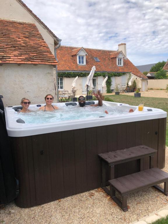 three people in a hot tub in a yard at Domaine de Praline - Le potager de Justin in Villerbon
