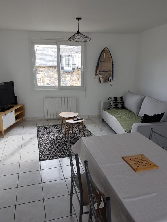 a white living room with a table and a couch at Le Julianais in Saint-Julien