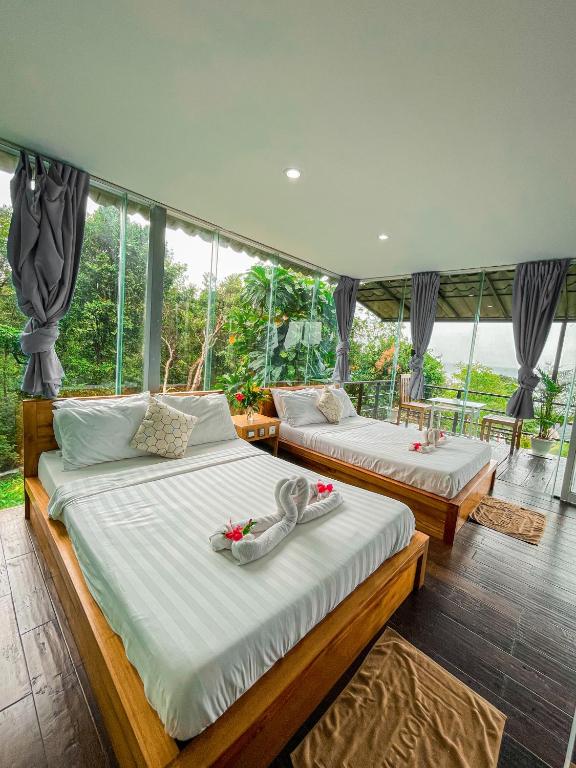 two beds in a room with a window at Ocean Lounge Bungalow in Koh Rong Island