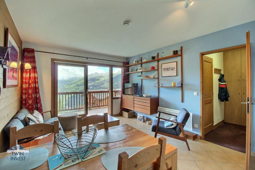a living room with a couch and a table at Sainte-Foy Station, Appartement 2 chambres rénové, Vue vallée, Skis aux pieds in Sainte-Foy-Tarentaise