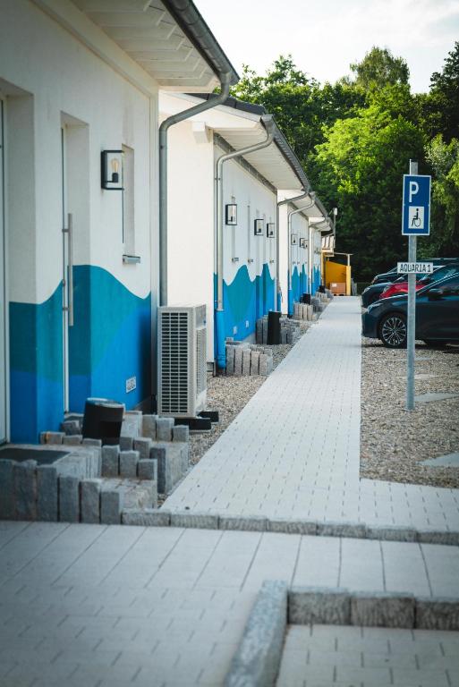a building with blue and white walls and a parking lot at Pension am Park in Rust