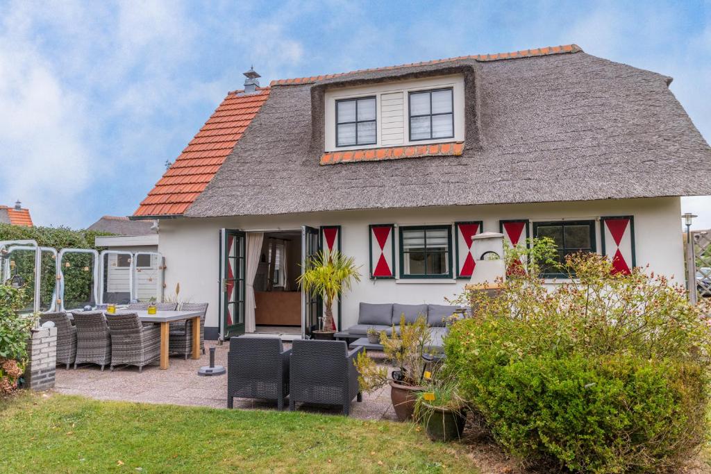 Casa con patio, mesa y sillas en Buitenplaats 67, en Callantsoog