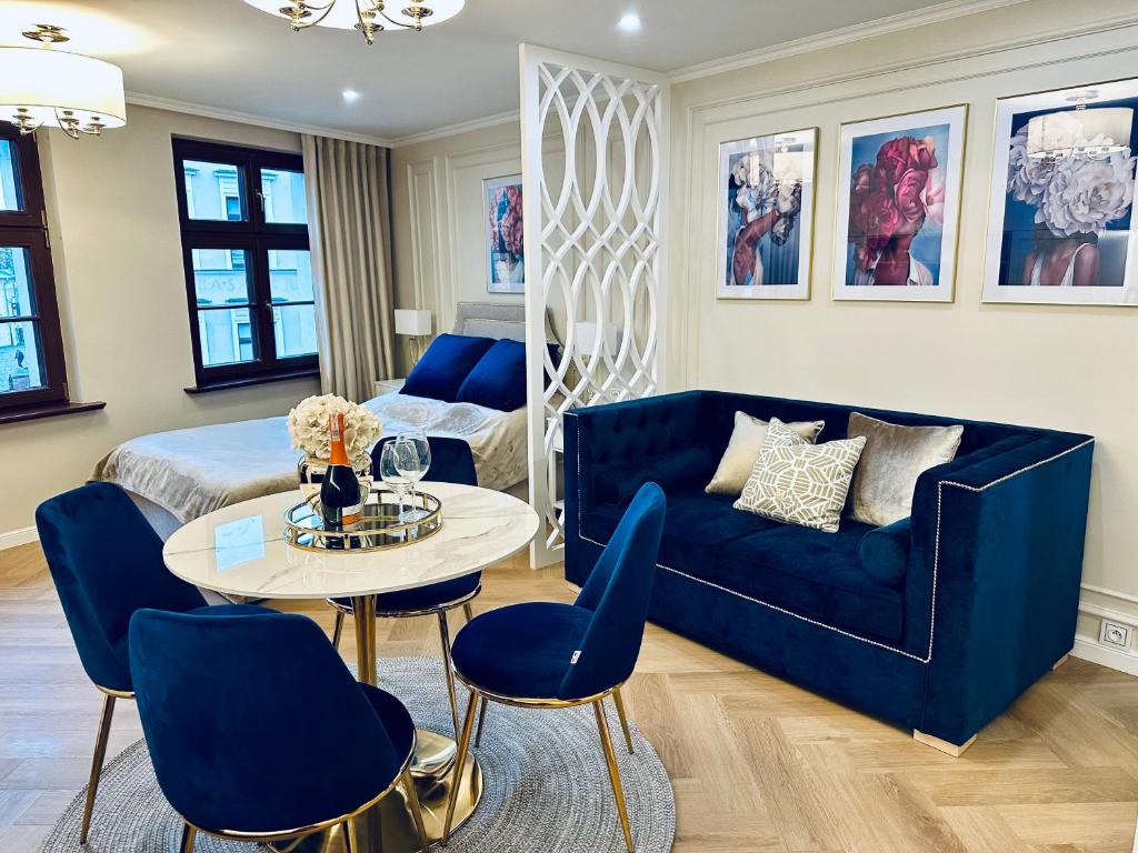 a living room with a blue couch and a table at Apartament Prosta 28 in Toruń
