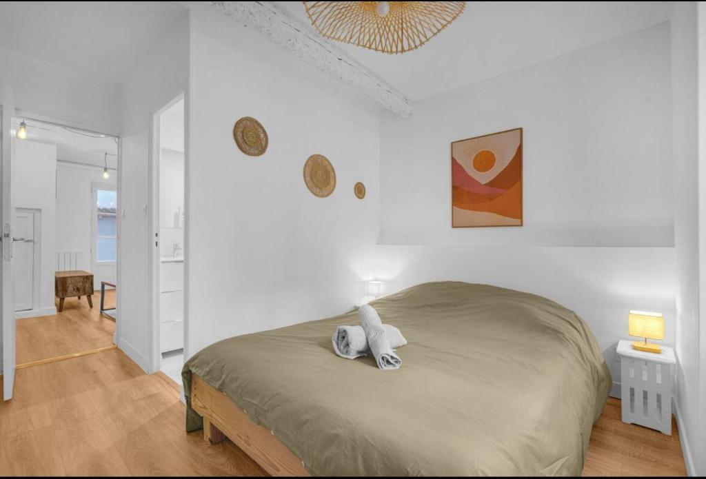une chambre avec un lit dans une pièce blanche dans l'établissement Grand deux pièces - Proche métro - Terrasse, à Toulouse