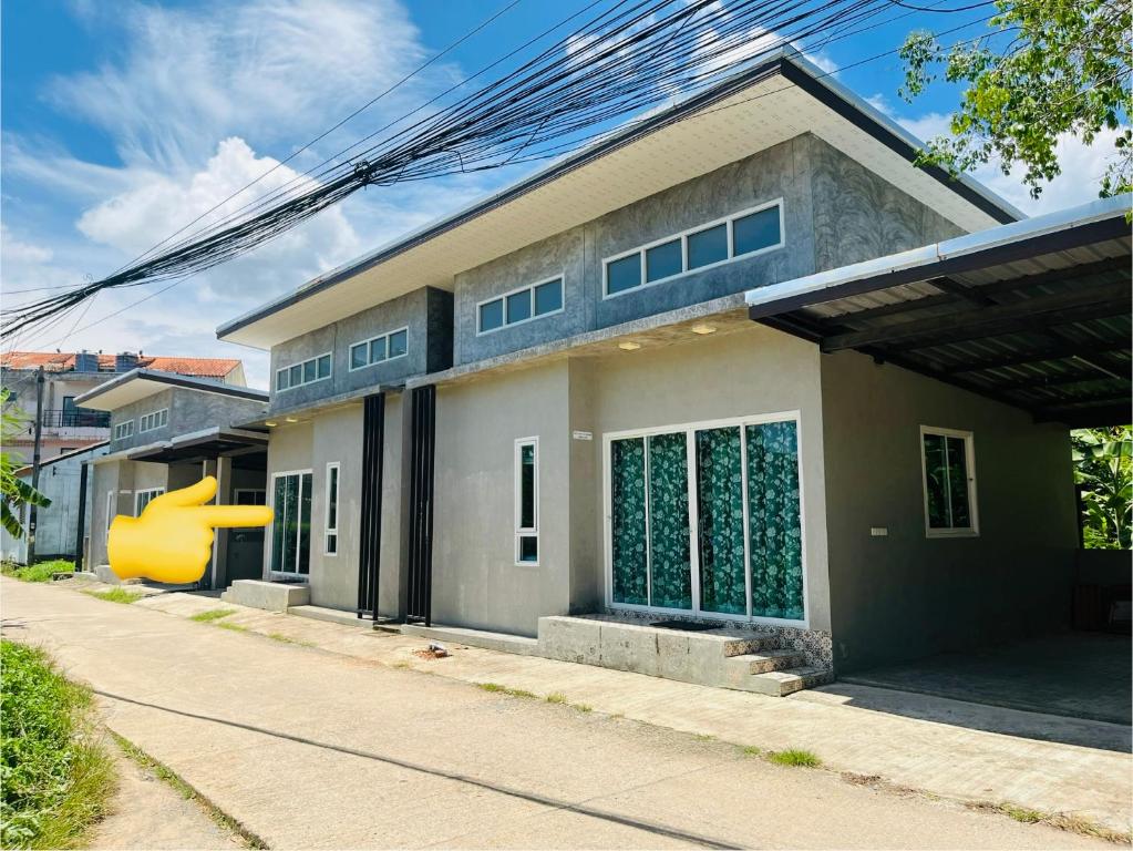 ein Haus mit einer großen gelben Skulptur davor in der Unterkunft บ้าน2ห้องนอน1ห้องน้ำเงียบสงบเดิน10นาทีถึงชายหาด in Ban Khlong Haeng