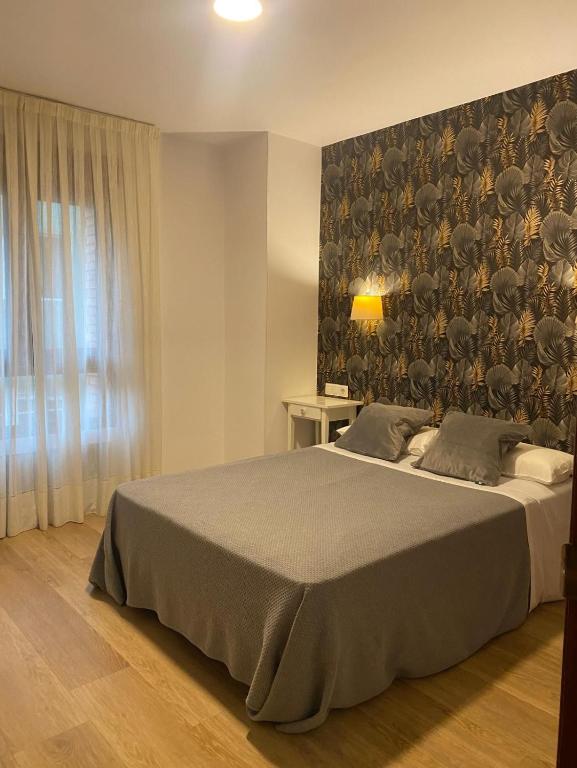 A bed or beds in a room at Hotel Ovetense