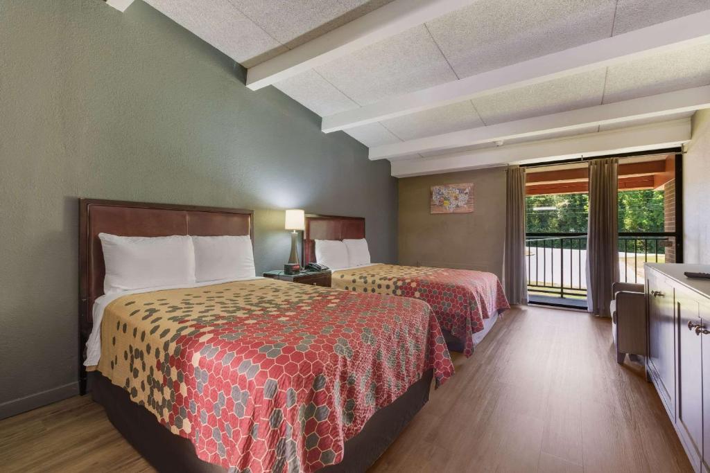 Una habitación de hotel con dos camas y una ventana. en Econo Lodge High Point - Archdale, en High Point