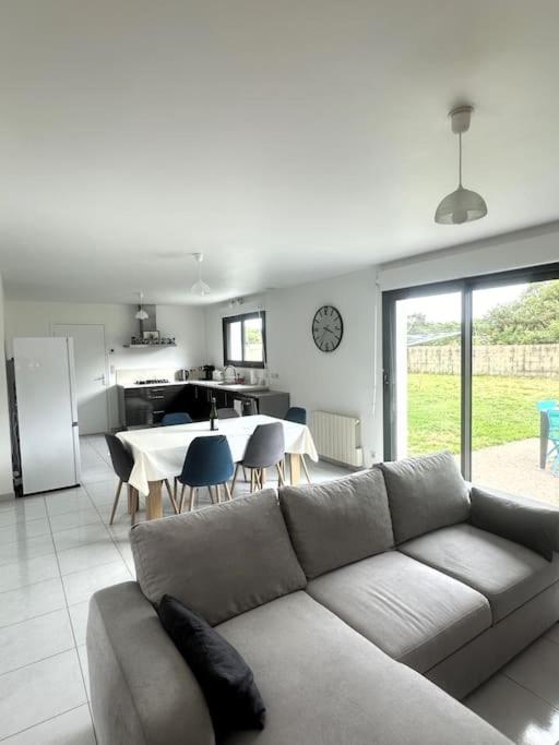 un salon avec un canapé et une cuisine avec une table dans l'établissement Chez Katerina - Plomeur proches plages, à Plomeur