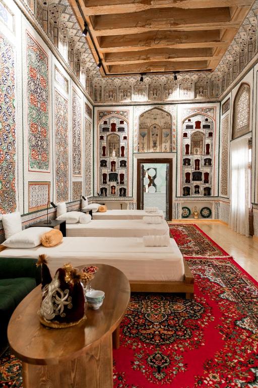a large room with four beds and a table at Barlos Noyob Boutique in Bukhara