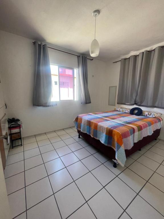 a bedroom with a bed with a colorful blanket on it at Apartamento Icaraí Atlântic village in Caucaia