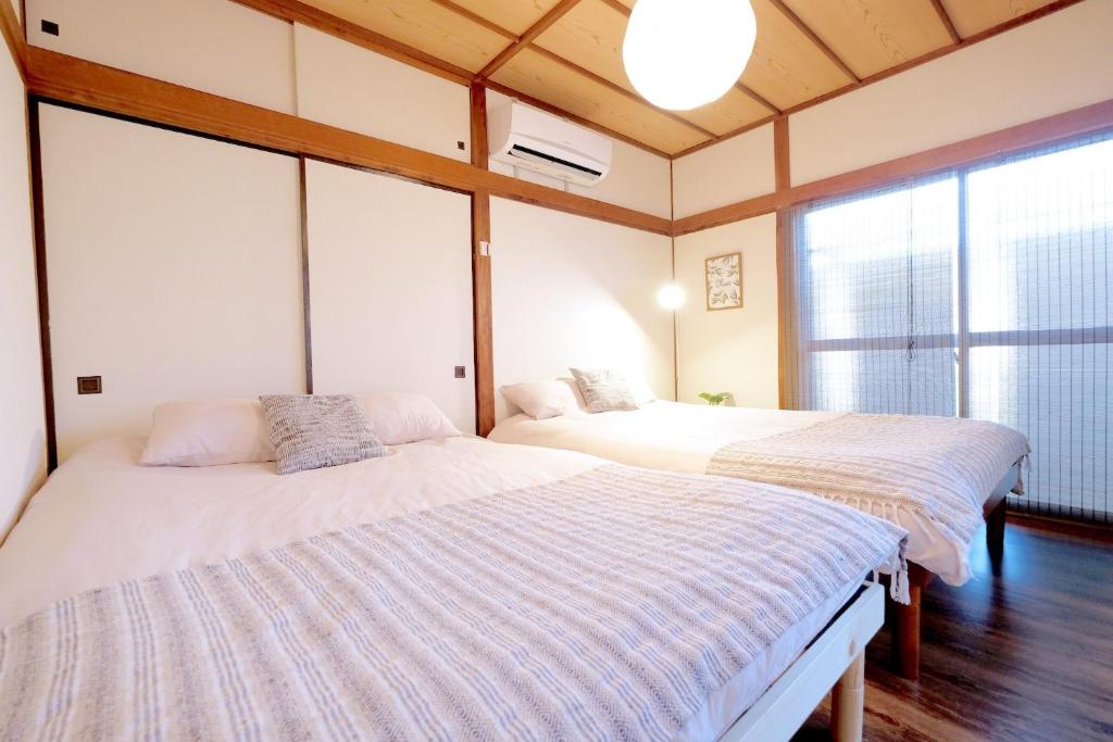 zwei Betten in einem Zimmer mit Fenster in der Unterkunft Daiichi Mitsumi Corporation - Vacation STAY 15355 in Musashino