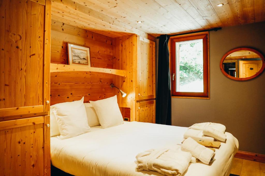 a bedroom with a bed in a wooden cabin at Joubarbe Violette by Lodji in Saint-Martin-de-Belleville