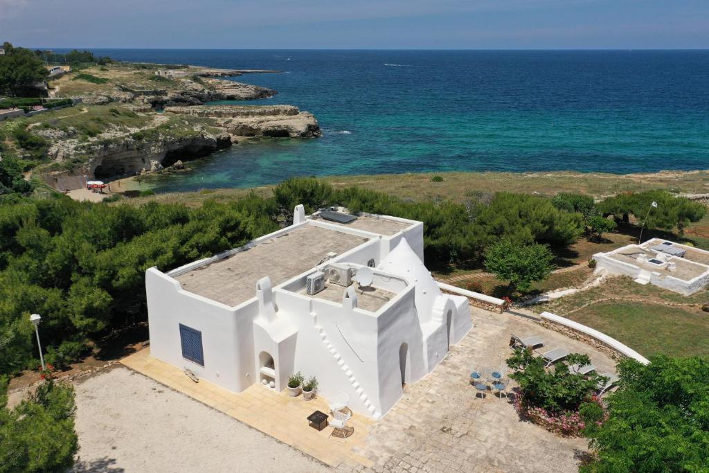 una vista aérea de una casa blanca junto al océano en Trullammare, en Monopoli