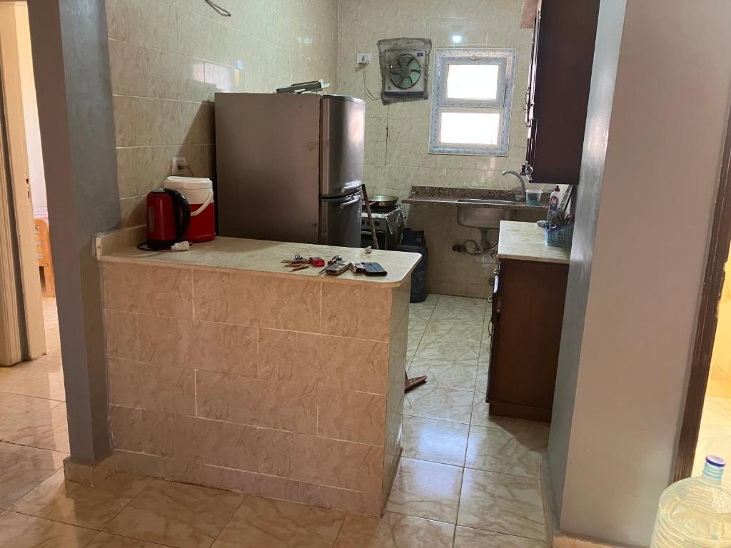 a kitchen with a counter with a refrigerator in it at Mina resort ras sudr in Makman