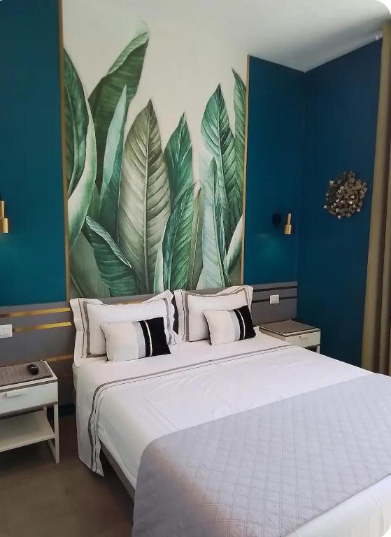 a bedroom with a large bed with a mural of leaves at Urban Home in Pompei