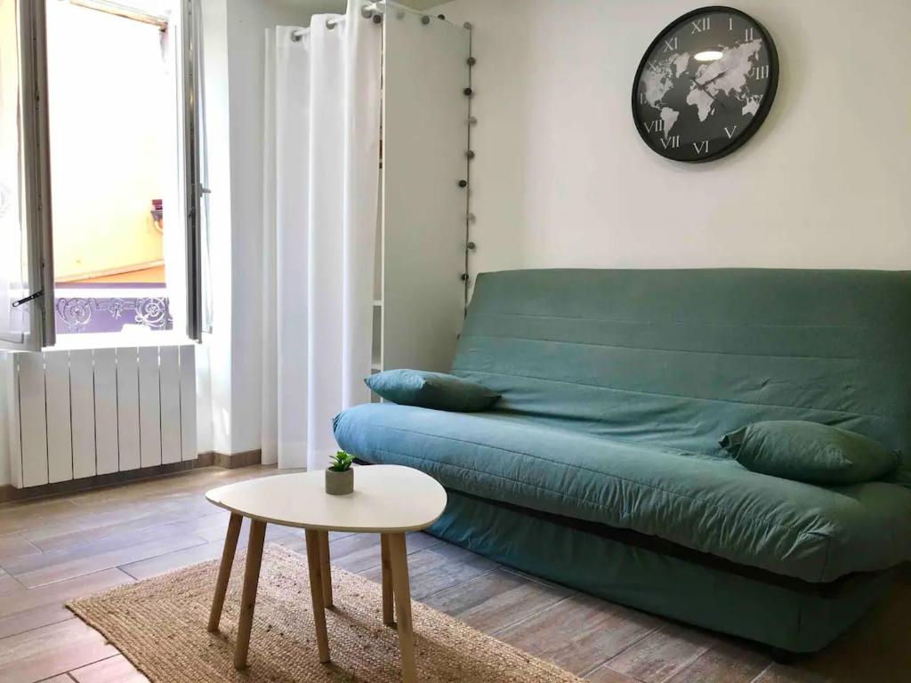 un canapé vert dans un salon avec une table dans l'établissement Le Calme en plein centre ville de BELFORT, à Belfort