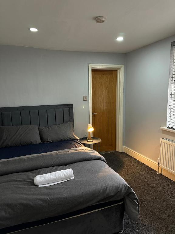 マンチェスターにあるBudget Room with Private Bathroomの大きなベッドと窓のある寝室