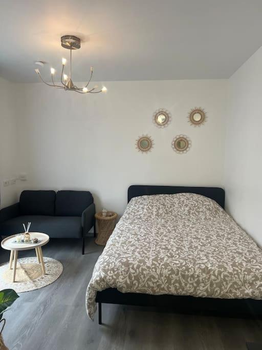 une chambre avec un lit et un canapé dans l'établissement Studio proche Disney et Paris, à Noisy-le-Grand