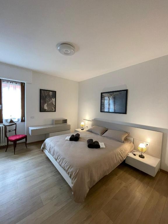 a large bedroom with a large bed with two lamps at Rustic Apartment -100mt from BerninaExpress in Tirano