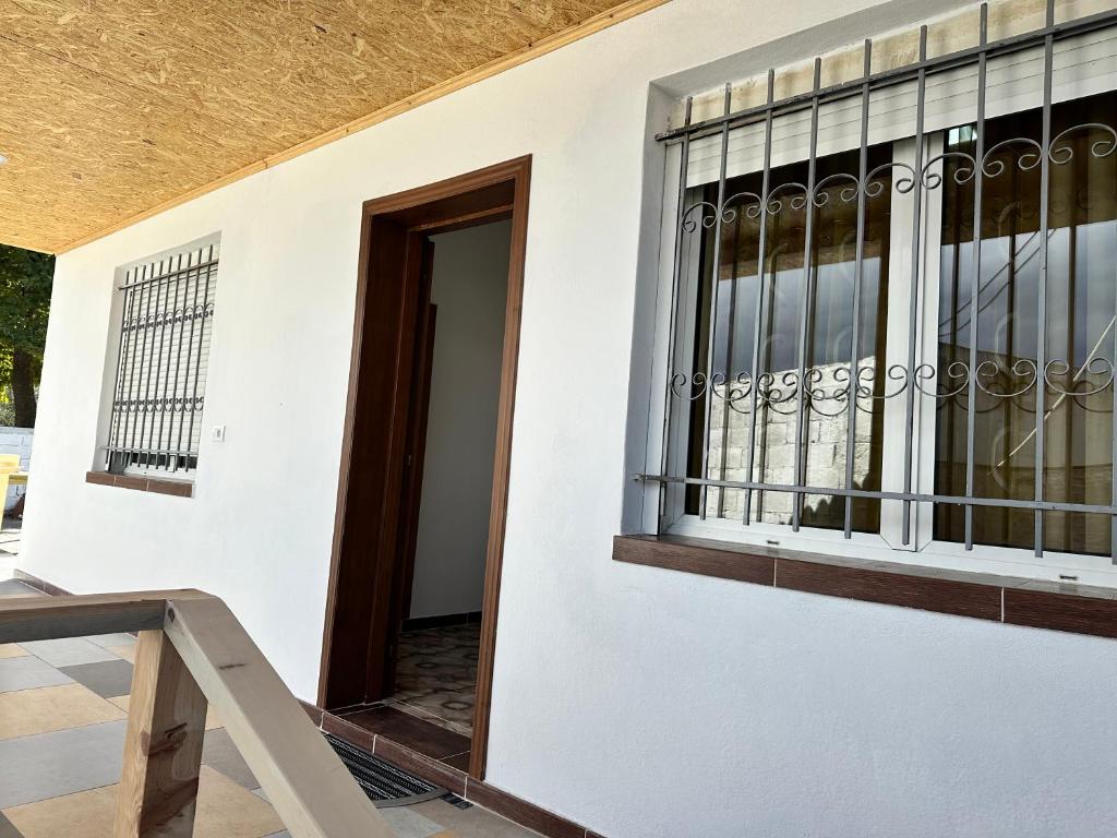 a building with a window and a wooden door at Gardenhouse2 in Mëmëlisht