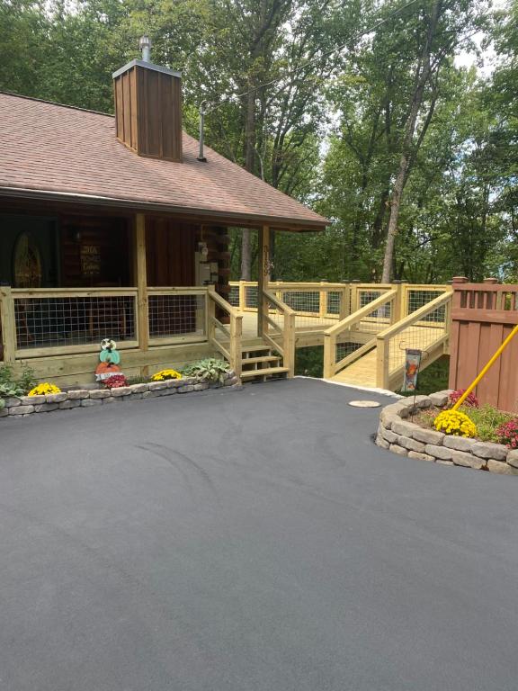 een huis met een houten hek en een oprit bij His Promises Cabin in Pigeon Forge