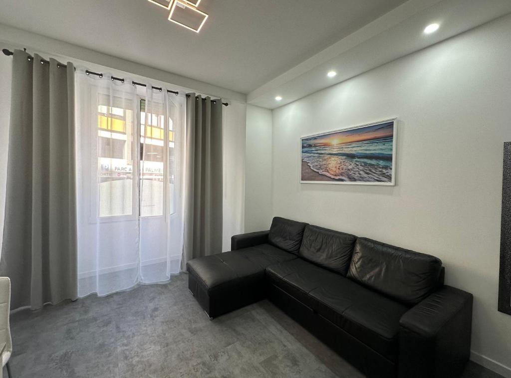 - un salon avec un canapé noir et une fenêtre dans l'établissement Appartement 3 pieces proche du Negresco, à Nice