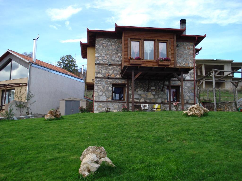 uma casa com um relvado verde em frente em Kleio em Elatochori