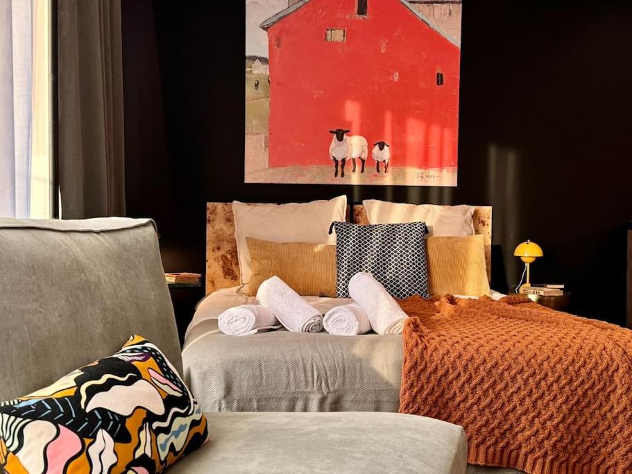a bedroom with a bed and a painting of sheep at Art & SunSki Studio z garażem podziemnym in Krynica Zdrój