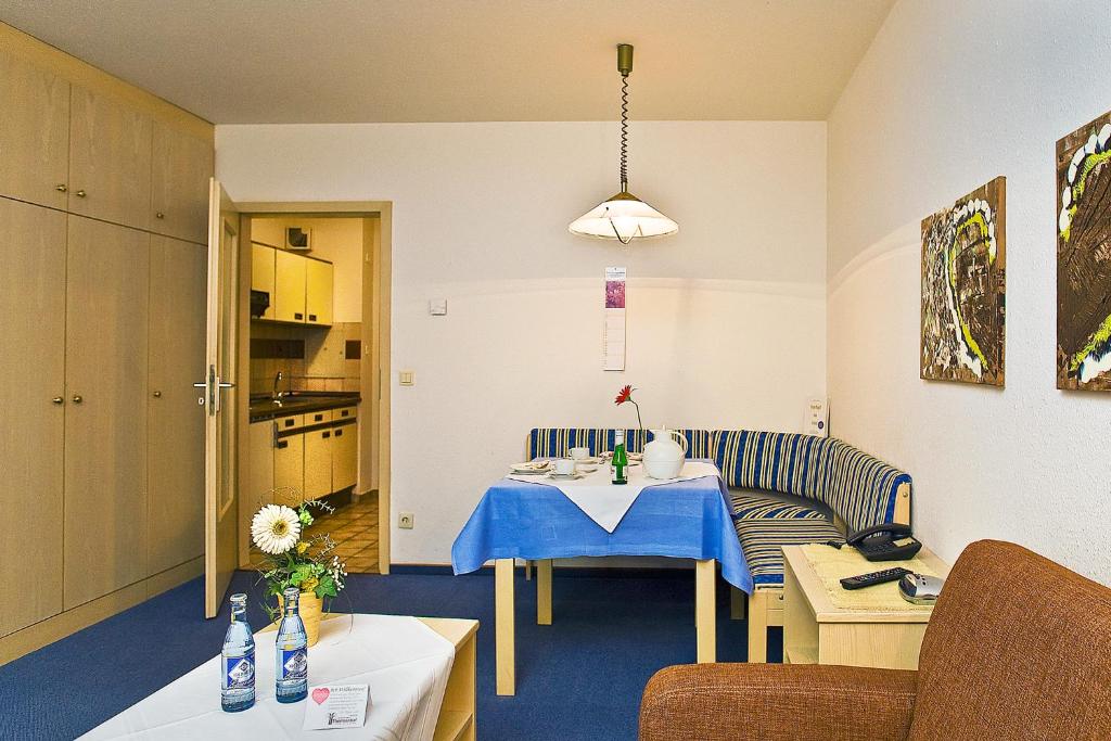 una pequeña sala de estar con mesa y sofá en Appartmenthaus Thermenhof, en Bad Füssing