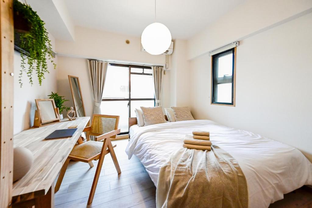 una camera da letto con un letto grande e una scrivania di New! Japandi 3 1BR in Prime Location-1 min to STN a Hakata